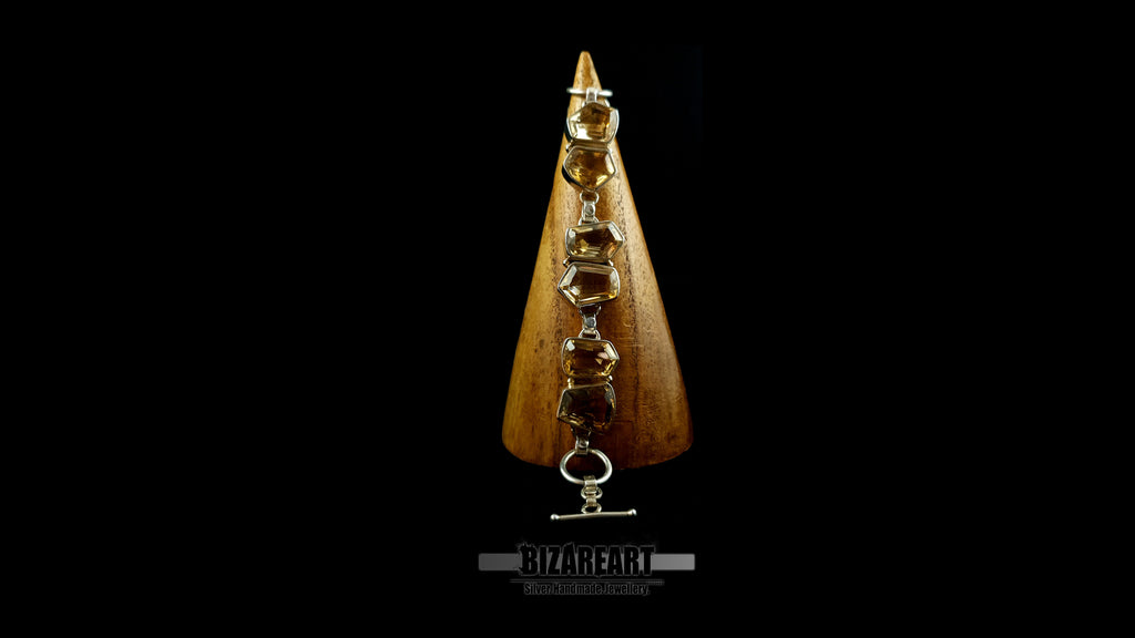 Sterling silver and citrine bracelet wrapped around a wooden display cone