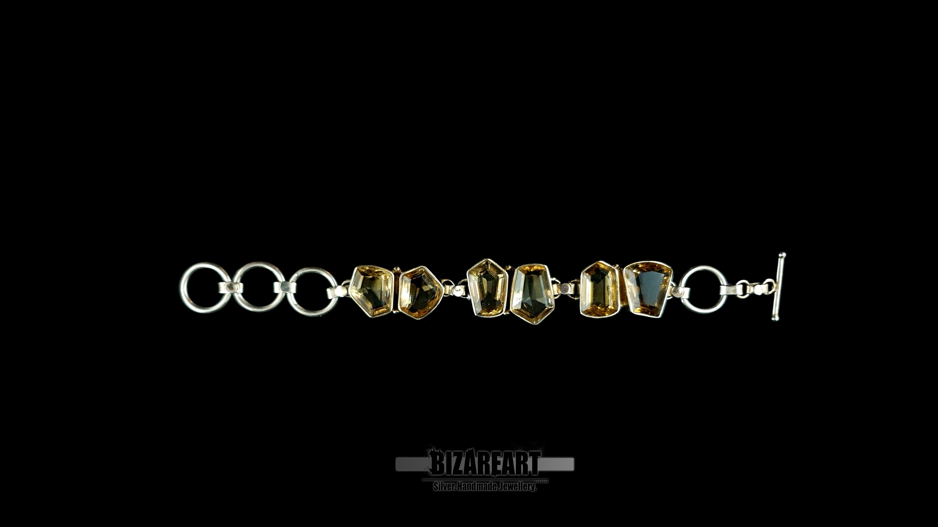 Flat lay top-down view of silver citrine statement bracelet laid flat showing link assembly