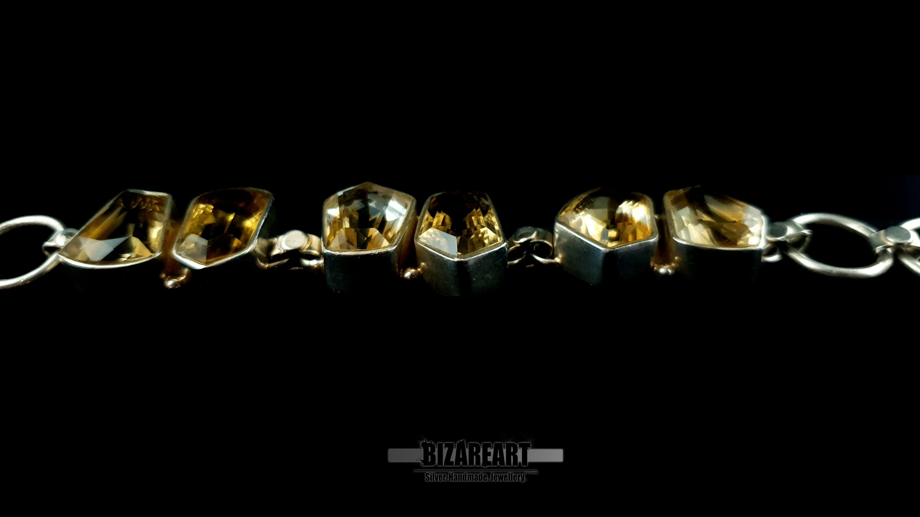 Macro close-up shot highlighting hand-brushed silver texture and raw citrine stone inclusions