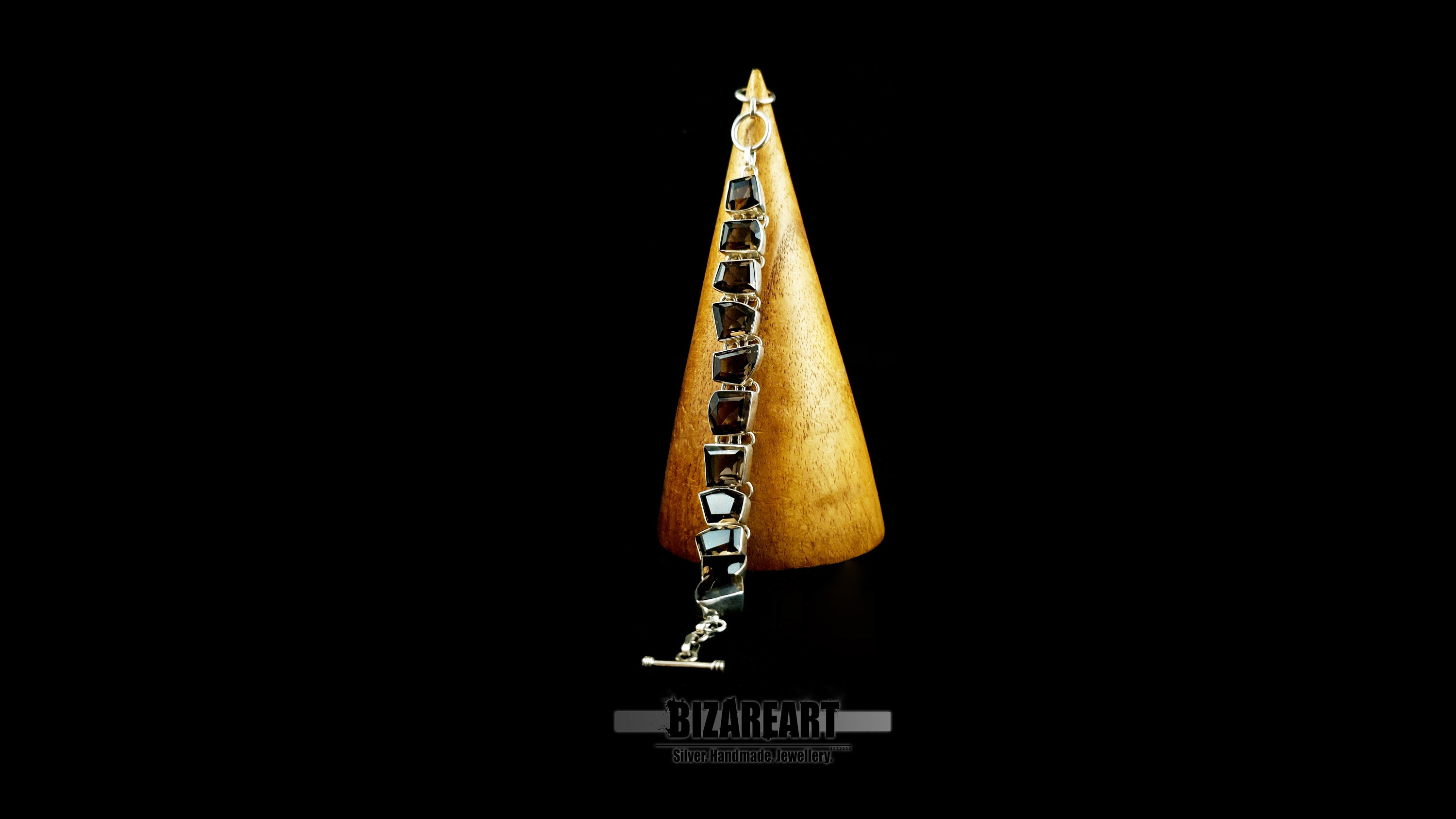 Handcrafted sterling silver bracelet with 11 raw smoky quartz stones on wooden cone.