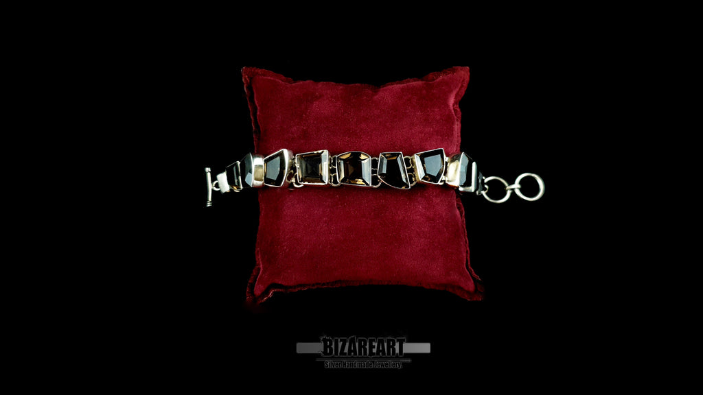 Heavy 38.5g artisan smoky quartz bracelet with toggle clasp on red velvet cushion.