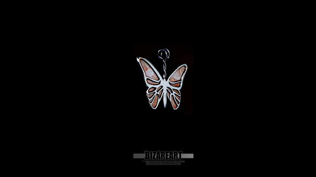 Close-up of a handcrafted .925 silver butterfly pendant with watercolor enamel wings against a black background.