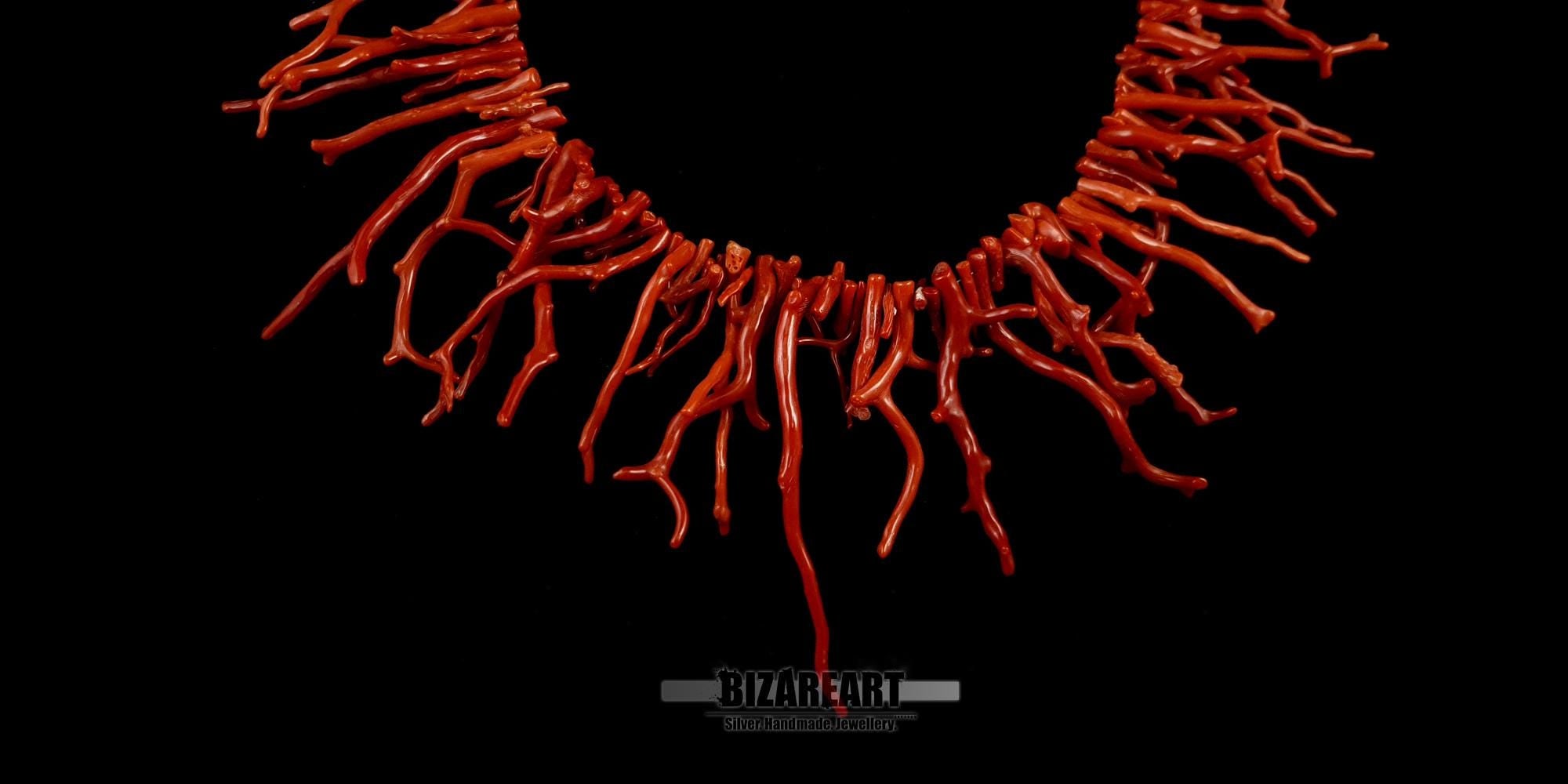 Macro view of polished Mediterranean red coral branches showing the natural texture and organic fiery red gradient.