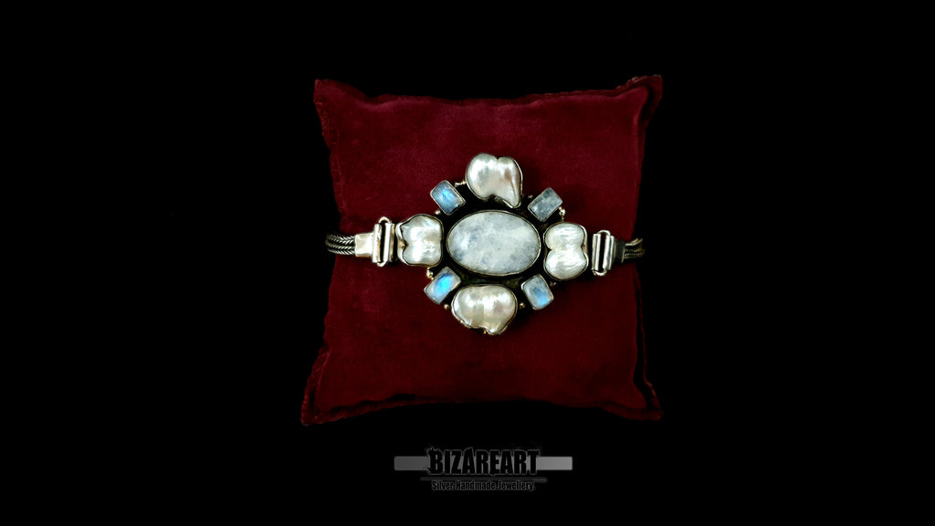 Close-up macro shot of central silver relic detailing the unique organic textures of 4 baroque pearls and the blue fire of 4 hand-set labradorite gems.