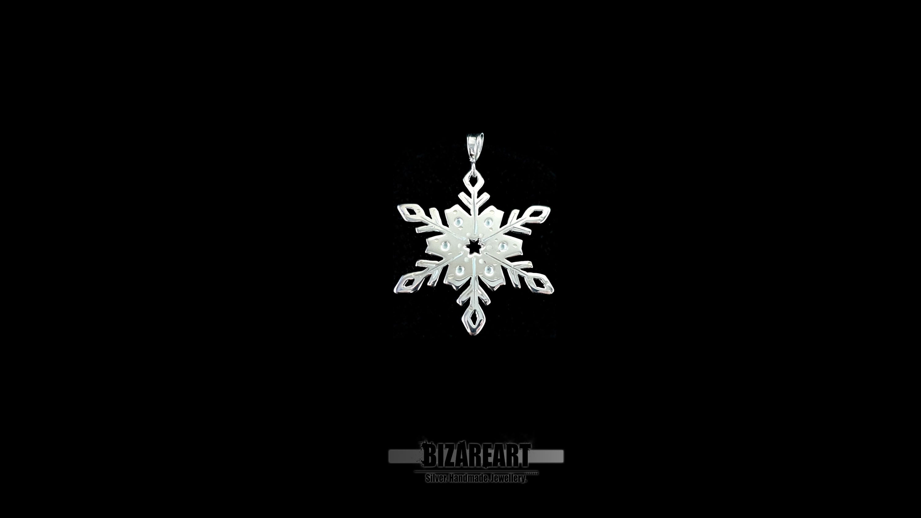 A high-contrast shot of the silver snowflake pendant against a solid black background, highlighting the reflective rhodium finish and transparent enamel work.
